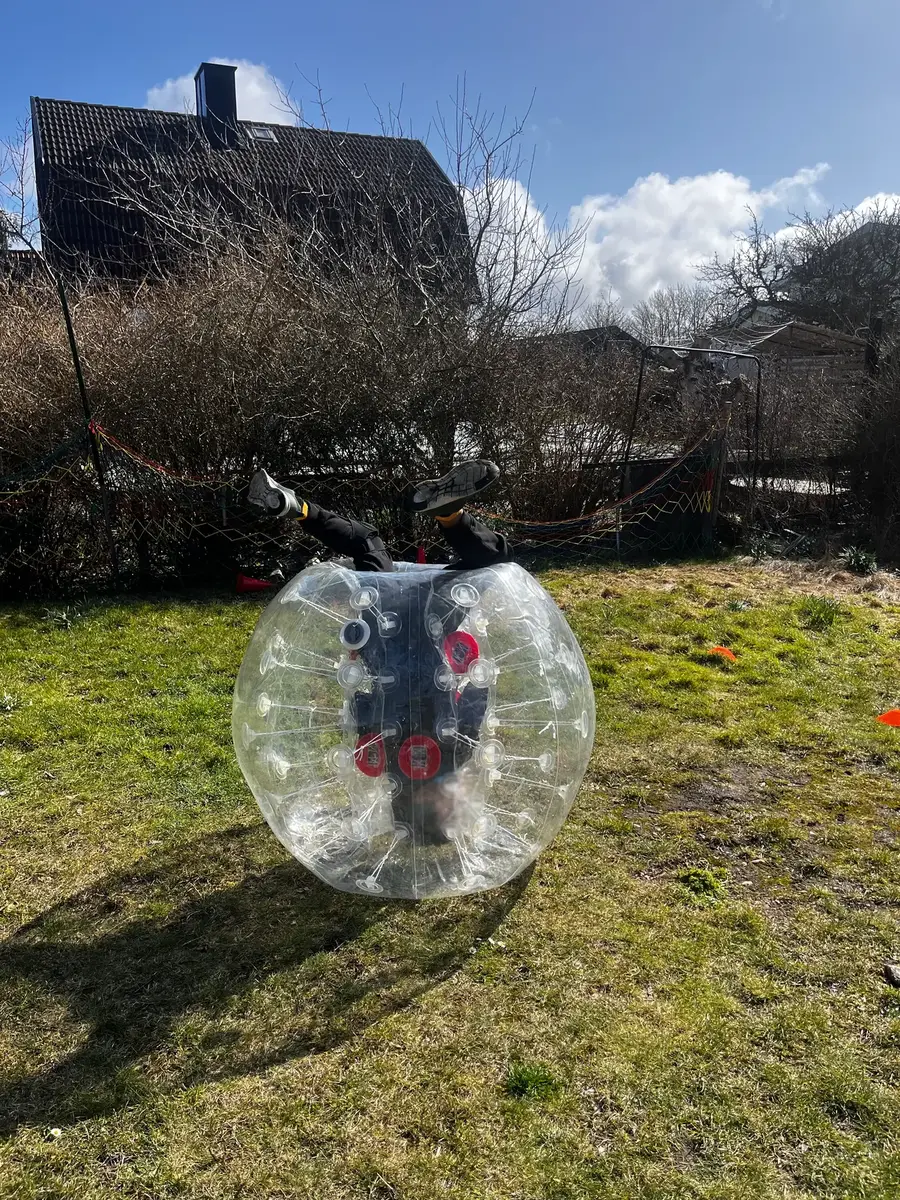 En spelare rullar runt tryggt i en bumperball på gräs
