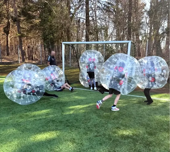 Barn spelar bumperballs framför ett fotbollsmål